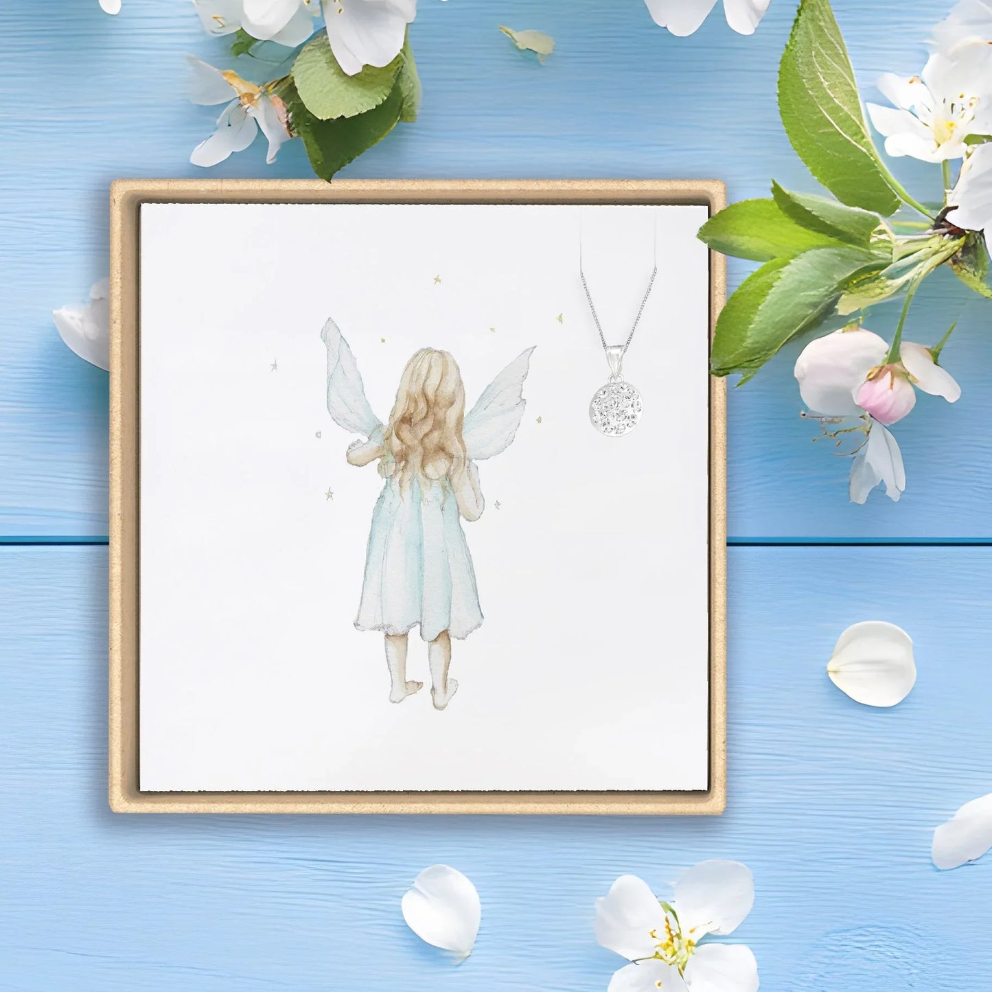 Handcrafted fairy card with silver necklace by Crumble and Core on blue wood background